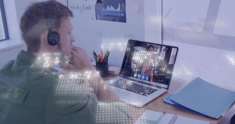 Remote team meeting on laptop with focused man wearing headset at modern desk workspace