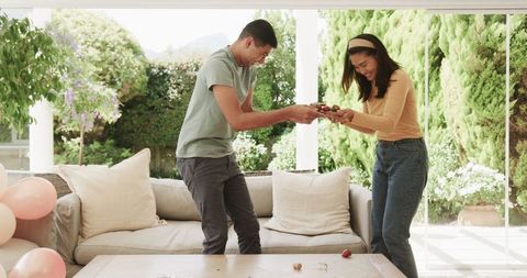 Young couple joyfully preparing birthday celebration with cake
