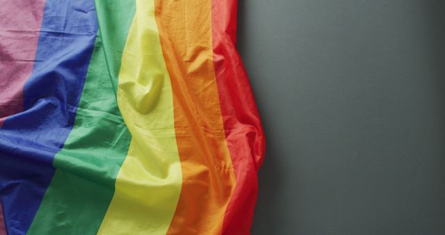 Image of creased rainbow flag lying on black background. gay pride, lgbt rights and supporting minority concept.