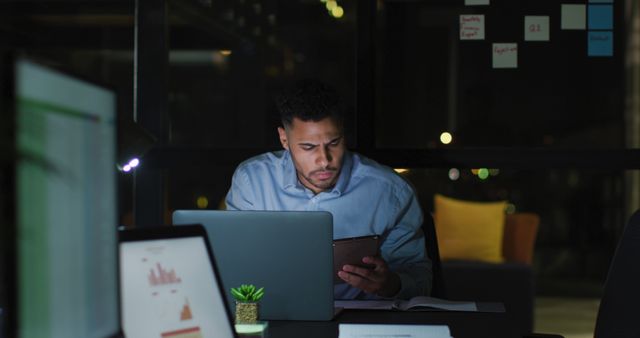 Young Professional Working Late at Modern Office with Laptop and Tablet - Download Free Stock Images Pikwizard.com