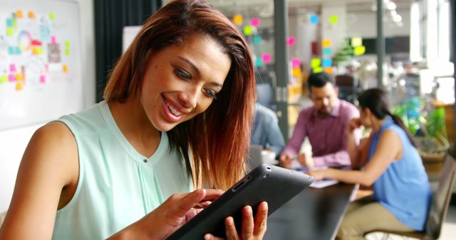 Smiling Businesswoman Using Tablet in Modern Office During Meeting - Download Free Stock Images Pikwizard.com