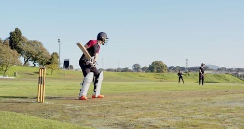 Cricket Match Action Shot on Green Field with Bat and Wicket Stumps