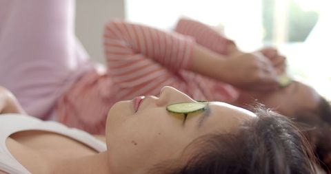 Relaxed Women Enjoying Skincare with Cucumber, Bright Indoor Atmosphere