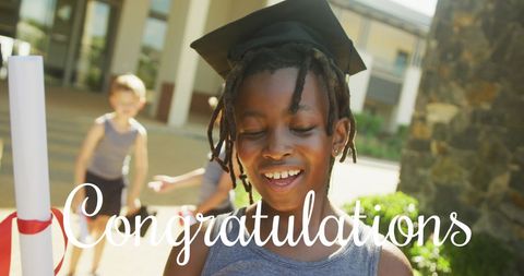 Joyful african american boy celebrating graduation outdoors