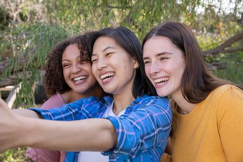Diverse Friends Smiling for Selfie in Sunlit Park