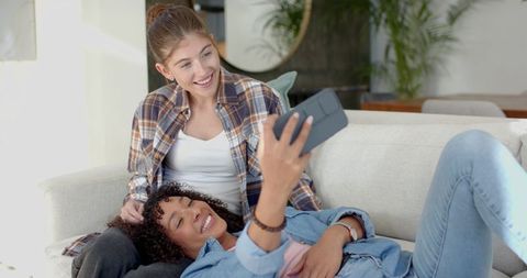 Diverse Women Exploring VR Technology Together in Cozy Living Room