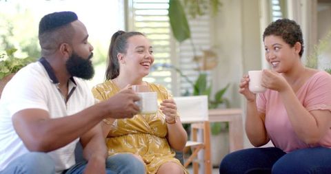 Friends Toasting with Coffee Mugs Celebrating Togetherness at Home