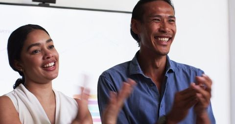 Happy colleagues celebrating successful meeting in office