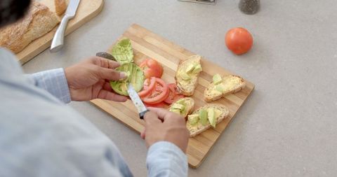 Preparing Fresh Avocado Toast on Wooden Cutting Board