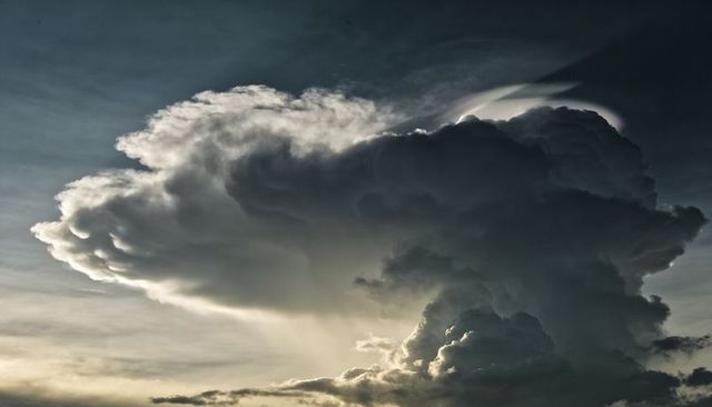Backlit Cumulonimbus Anvil Casting Golden Sun Rays Over Dramatic Storm Sky at Dusk