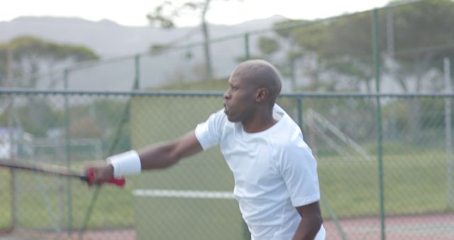 Focused Male Tennis Player Hitting Ball on Outdoor Court - Download Free Stock Images Pikwizard.com