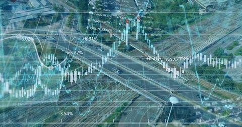 Live financial overlay on aerial highway and rail interchange showing market volatility