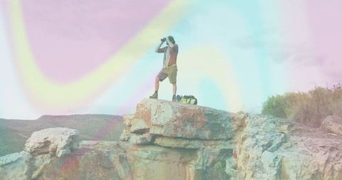 Hiker with Binoculars at Cliff Edge Embracing Adventure