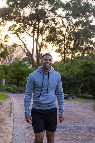 Man Walking on Park Trail at Sunset in Comfortable Activewear
