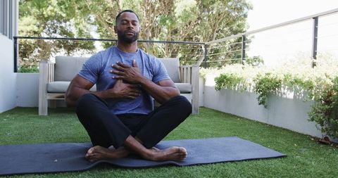 Mature man practicing deep breathing on balcony mat promoting mindfulness and stress relief