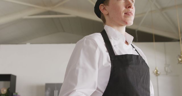 Woman proudly standing in modern kitchen. Excellent for illustrating concepts of professionalism in culinary arts, female empowerment in the workplace, and showcasing cooking techniques. Useful for articles on female chefs, culinary schools, and professional cooking environments.