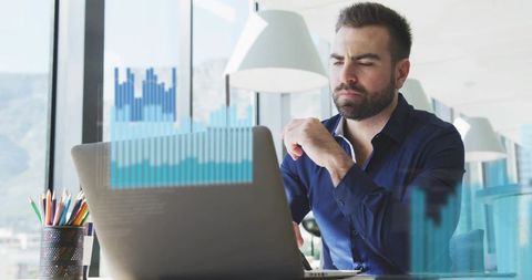 Business analyst analyzing live data charts on laptop in bright modern city office