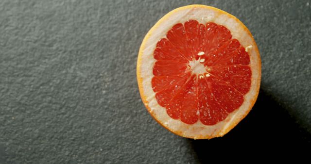 Fresh grapefruit half against a dark slate background - Download Free Stock Images Pikwizard.com