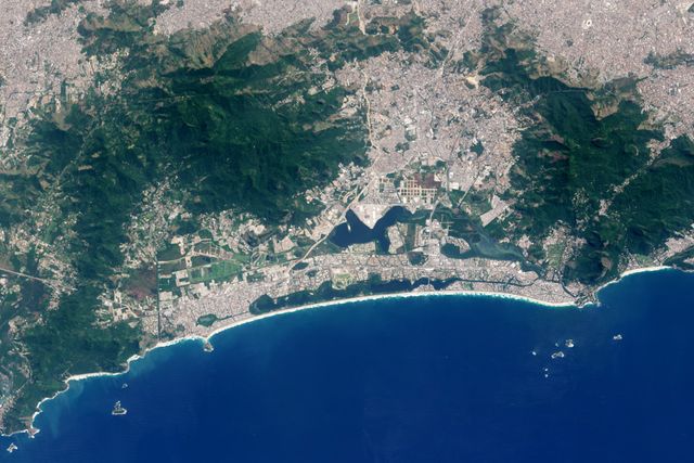 This detailed aerial shot of Rio de Janeiro shows the city's Olympic Park and surrounding areas as captured from space. Ideal for use in articles or presentations about urban development, geography, Olympics, satellite imagery, or NASA's Earth observation missions. This image beautifully highlights the contrast between urban areas, natural landscapes, and the Atlantic coastline. It is perfect for educational and informative purposes, providing a unique perspective on the city known for hosting the 2016 Summer Olympics.