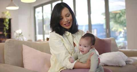 Mother Cuddling Infant in Bright Living Room Setting