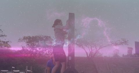 Athlete climbing pillar with spotter in outdoor fitness course