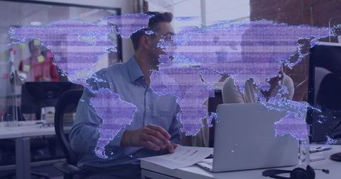 Collaborative team gesturing at laptop with holographic world map overlay in coworking office
