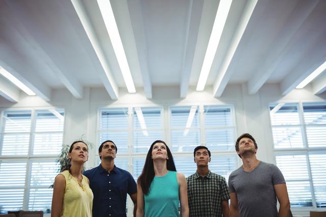 Group of business executives looking up in the office