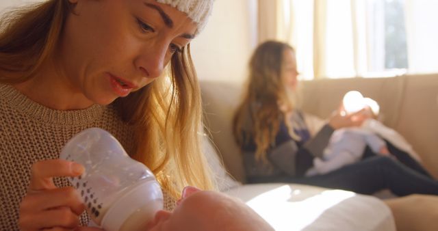 Mother Feeding Baby with Bottle in Cozy Living Room - Download Free Stock Images Pikwizard.com