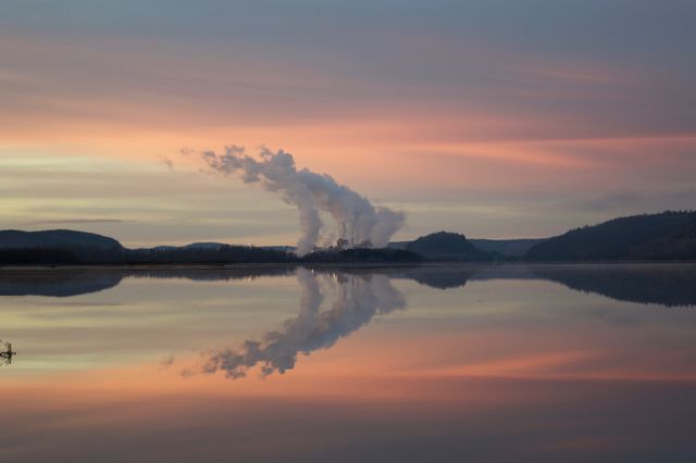 Industrial Landscape with Reflected Smoke at Sunrise Over Calm Water - Download Free Stock Photos Pikwizard.com