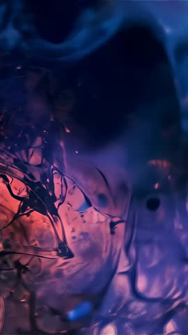 Vertical macro video showing swirling ink tendrils and pigments in fluid marbling with moody light