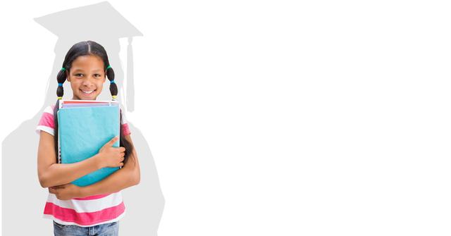 This image features a cheerful young girl holding books with a graduation cap silhouette in the background. Ideal for promotions regarding educational programs, motivational content for young students, or illustrating future aspirations and academic achievement.