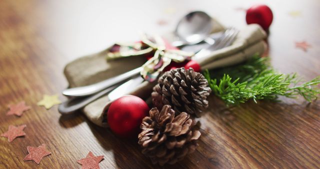 Image of christmas decorations with bauble and pine cones and cutlery on wooden background - Download Free Stock Photos Pikwizard.com