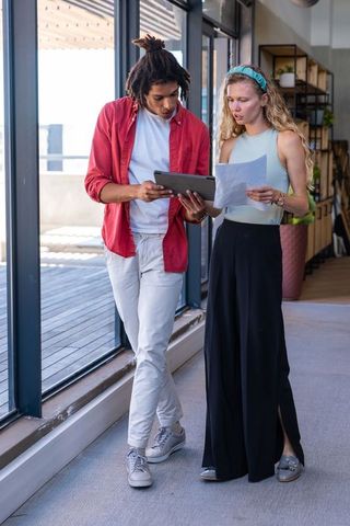 Colleagues Collaborating with Tablet and Document in Contemporary Office