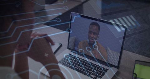 Man wearing headset joining remote meeting on laptop with digital tech overlay