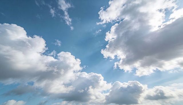 Dramatic Sunlight Streaming Through Cumulus Clouds Over Blue Sky with Crepuscular Rays