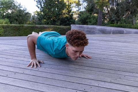 Athletic Male Performing Push-Ups on Outdoor Wooden Deck