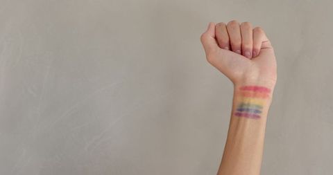 Person Showing Rainbow Stripes on Inner Wrist Against Light Background