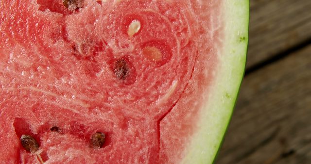 This vibrant close-up captures a ripe watermelon section with detailed texture and visible seeds. Ideal for food blogs, summer-themed promotions, healthy eating campaigns, and fruit advertisements. Provides a refreshing, appetizing visual perfect for a variety of seasonal content.