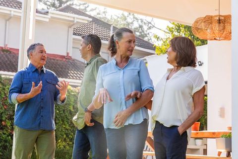 Group of Mature Friends Socializing Outdoors on Patio