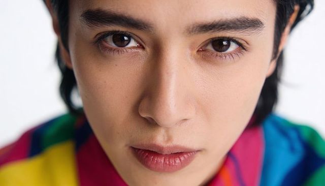 Intimate asian man close-up portrait wearing vibrant colorblock shirt, studio headshot