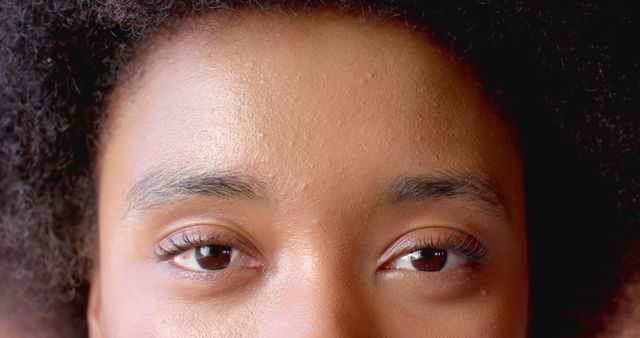 Close-up of brown eyes with natural eyebrows, showcasing beauty and emotion. Ideal for use in beauty, skincare, or fashion contexts. Can be used in adverts, blogs, and magazines focusing on beauty, natural skincare routines, and personal care.