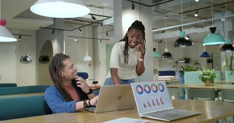 African American Coworkers Collaborating over Laptops in Modern Coworking Space