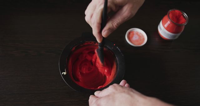 Hands Mixing Red Paint in Bowl on Dark Wooden Surface - Download Free Stock Images Pikwizard.com