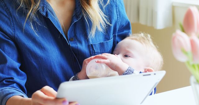 Mother multitasking with baby and tablet - Download Free Stock Images Pikwizard.com