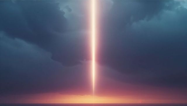 Dramatic vertical beam of light illuminating stormy seascape