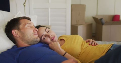 Happy Couple Resting in Bedroom with Moving Boxes