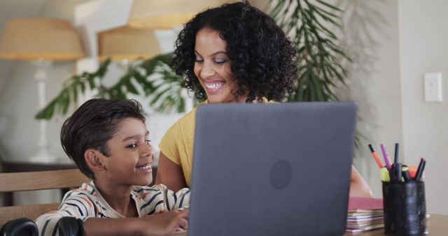 Smiling Mother and Son Using Laptop Together at Home - Download Free Stock Images Pikwizard.com