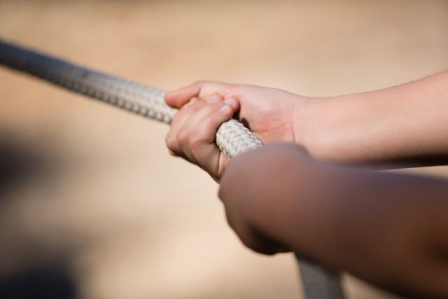 Hands of kid practicing tug of war during obstacle course in the boot camp