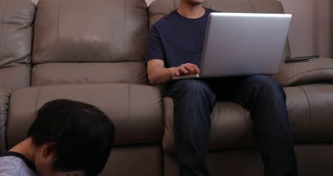 Father and Son Using Technology in Living Room