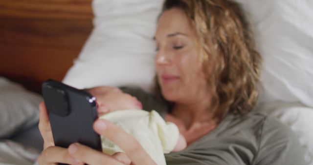 Mother Holding Baby While Using Smartphone in Bed - Download Free Stock Images Pikwizard.com